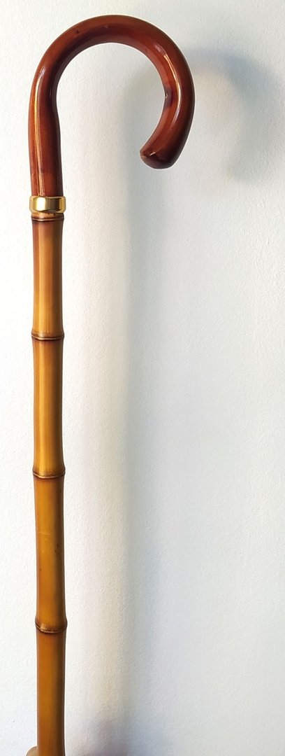 Bastón con empuñadura curva de madera. Palo caña de bambú gruesa. Contera de goma.